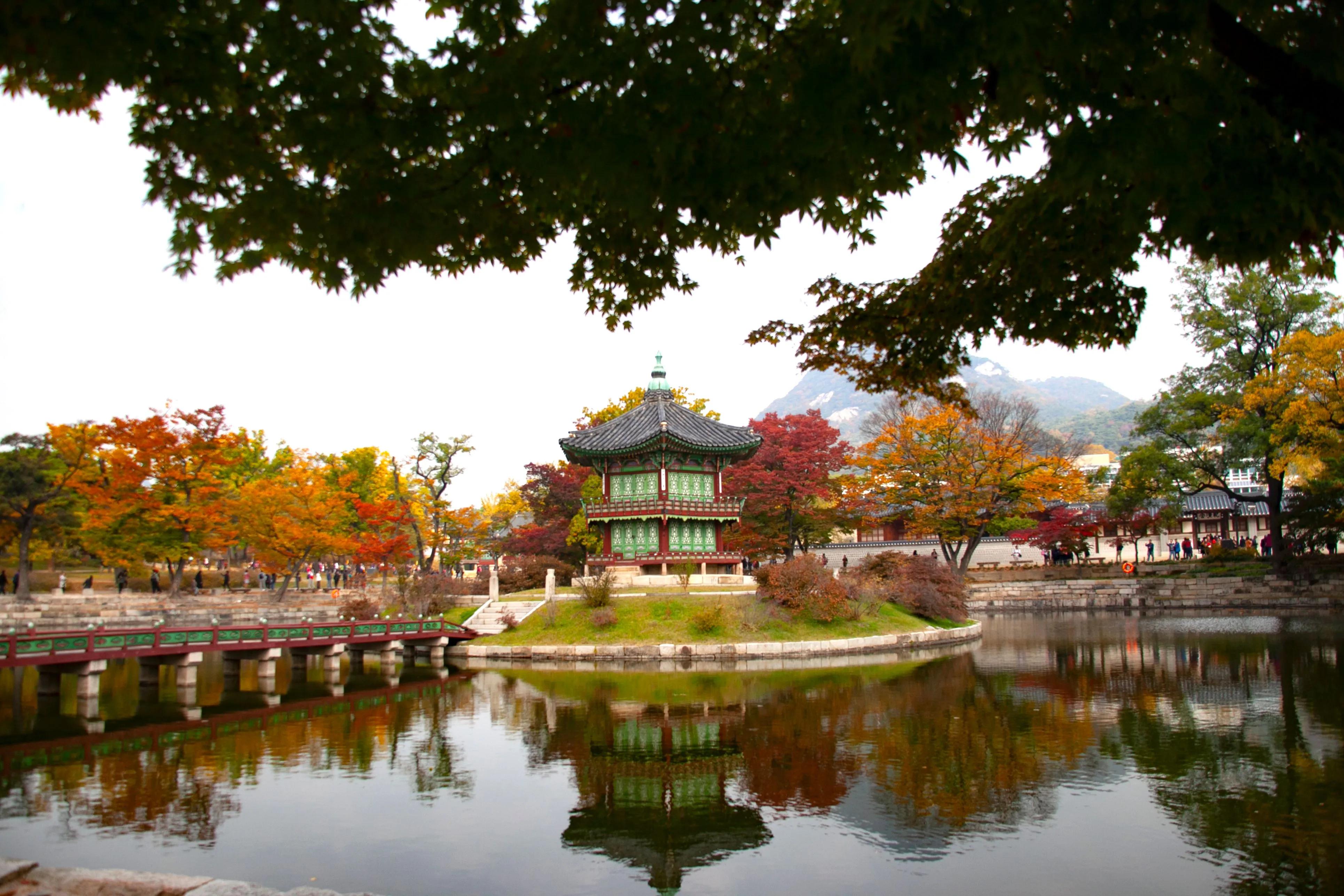 Hyangwonjeong Pavilion at Gyeongbokgung Palace in Seoul, South Korea, surrounded by autumn foliage reflecting in the pond