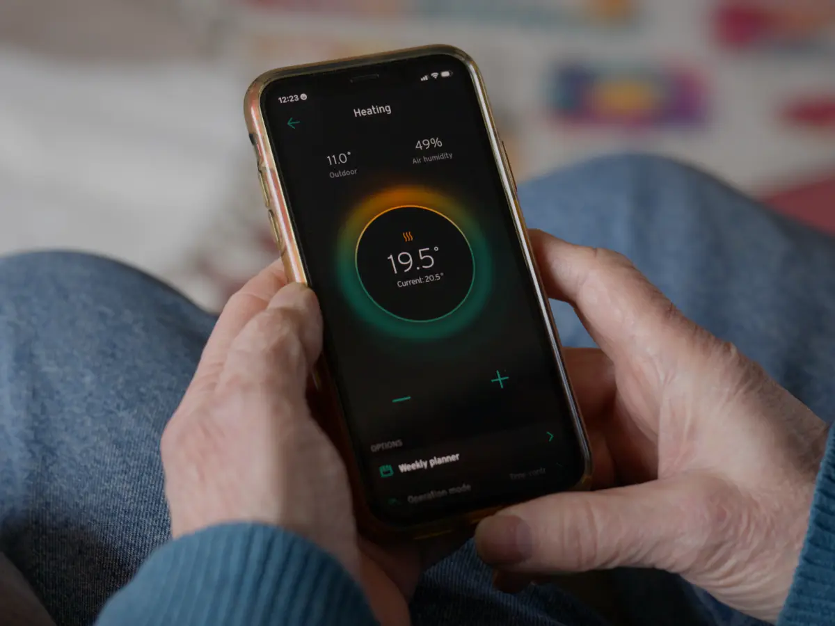 Warmtepomp-app op een telefoon in iemands hand