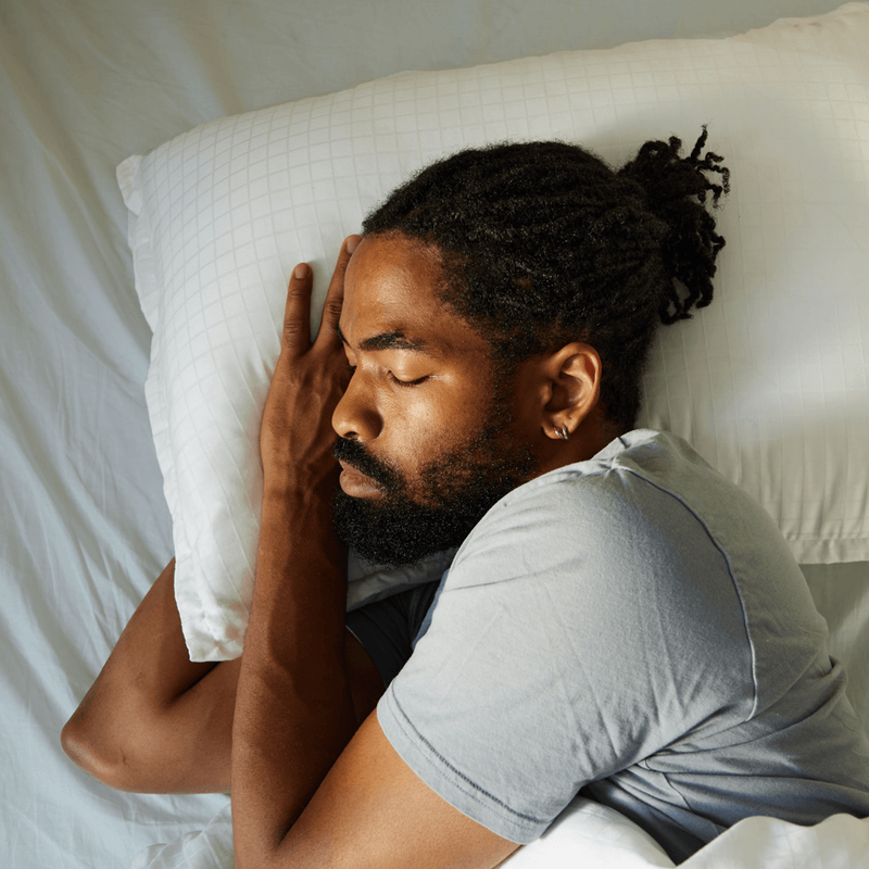 A photo of a person sleeping comfortably in bed.