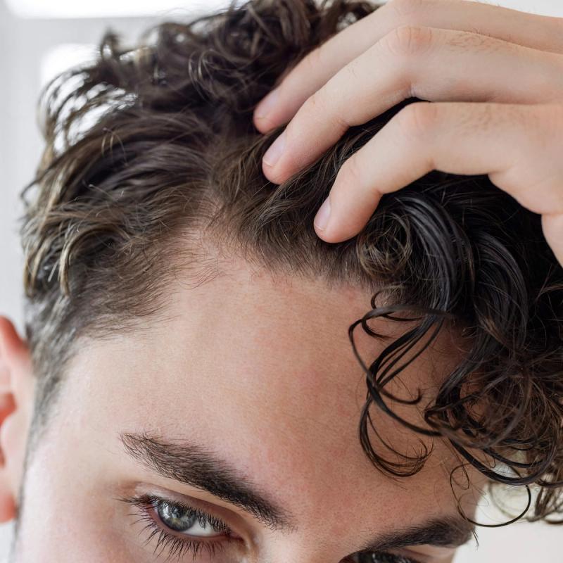 Close up of man with hand in hair.