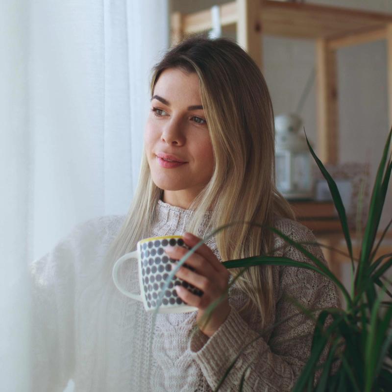 Peaceful woman with a mug of tea looking out the window