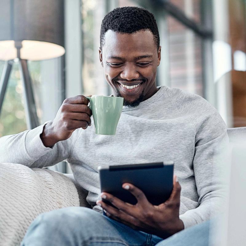 Man on Tablet Sitting on Couch