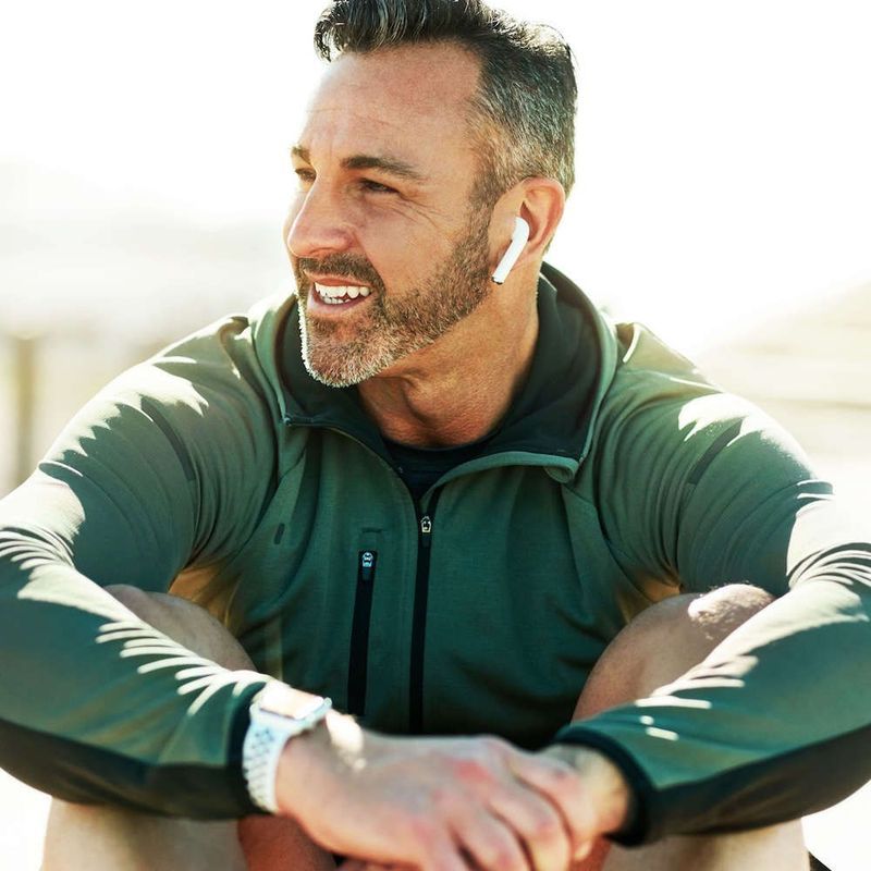 A smiling, confident man sitting outside
