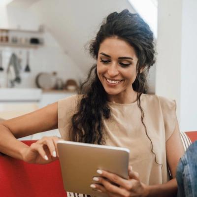 Photo of a smiling, healthy woman looking at a tablet