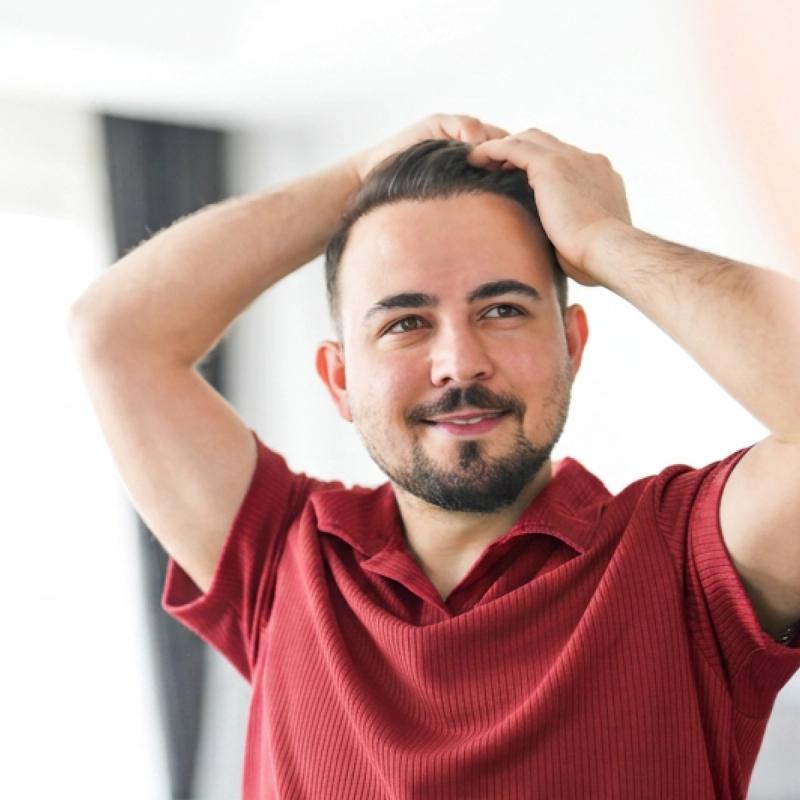 Smiling man running his hands through his hair 