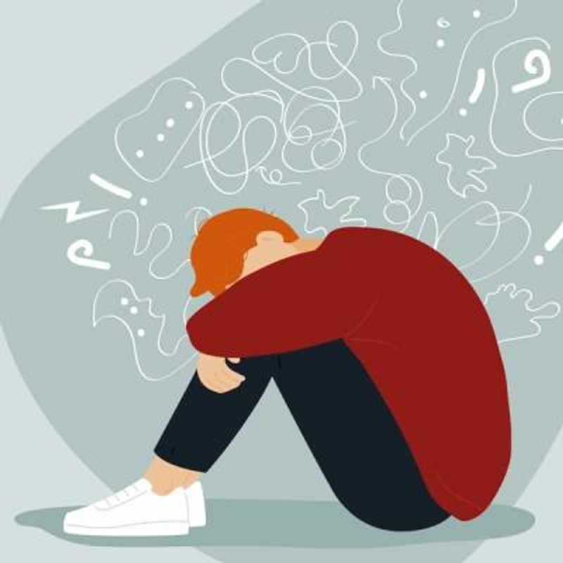 Illustration of a man with arms wrapped around his knees and his head down