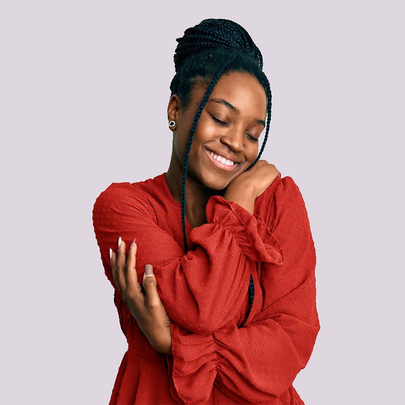 Smiling woman hugging herself