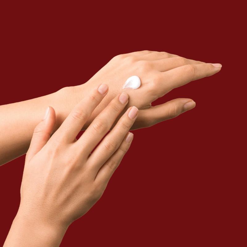 Close-up of hand putting cream on other hand