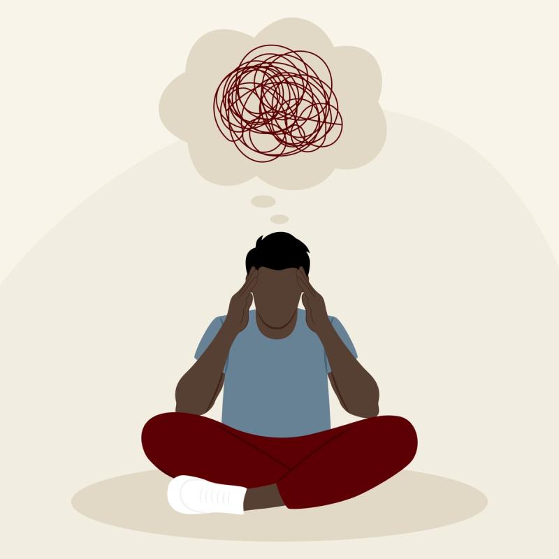 Man sitting cross-legged with hands to head