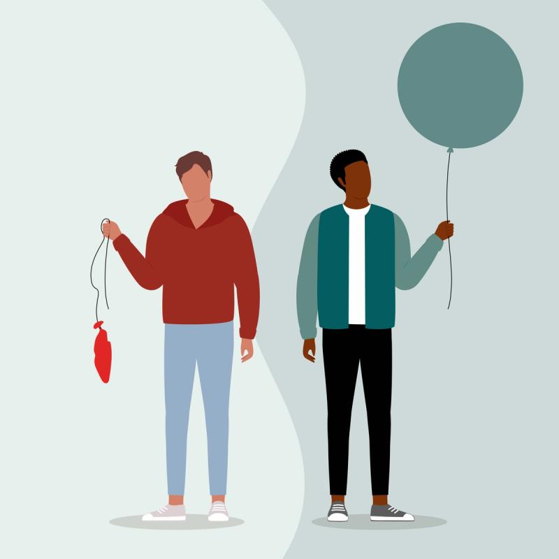 One man holding deflated ballon and other holding a inflated ballon.  