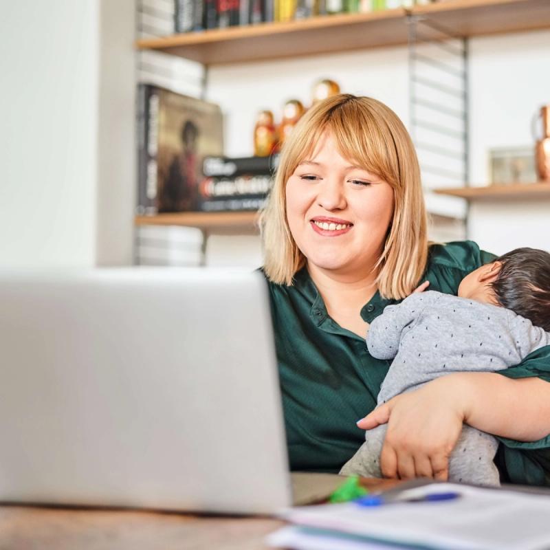 Mother Holding Baby, Completing Assessment on Computer