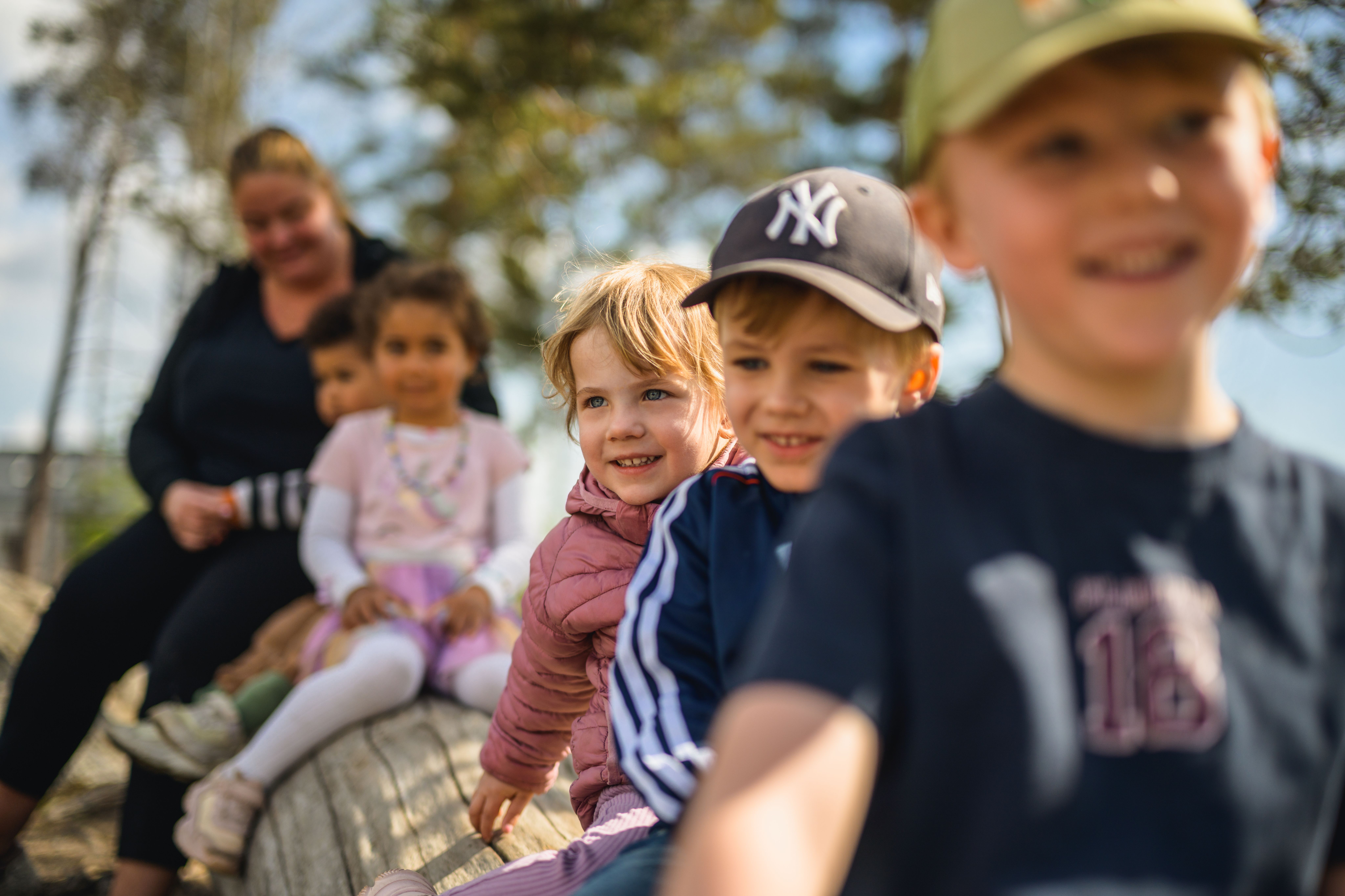 barn som sitter på träd tillsammans med pedagog