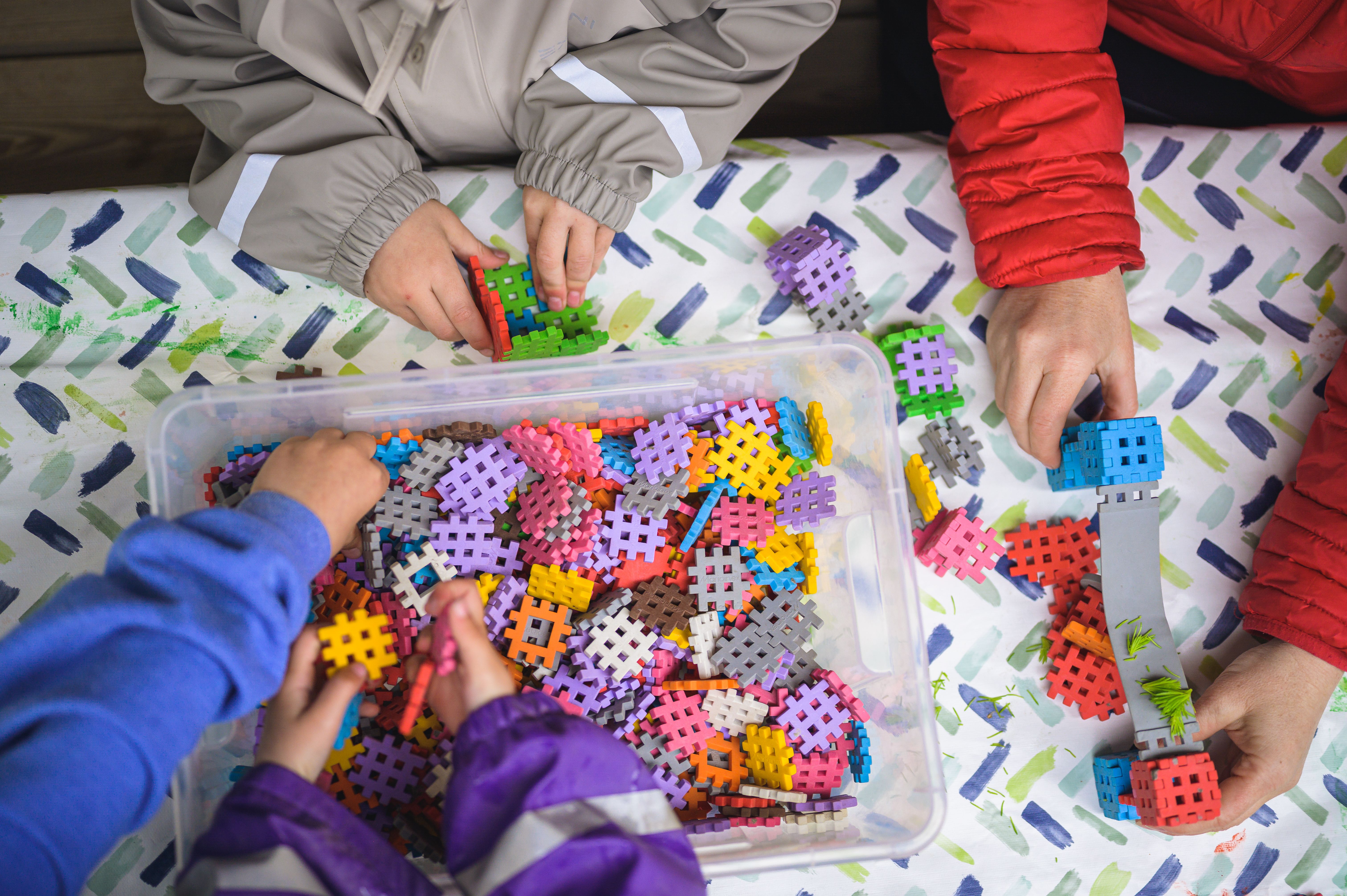 barnhänder som leker med plusplus utomhus