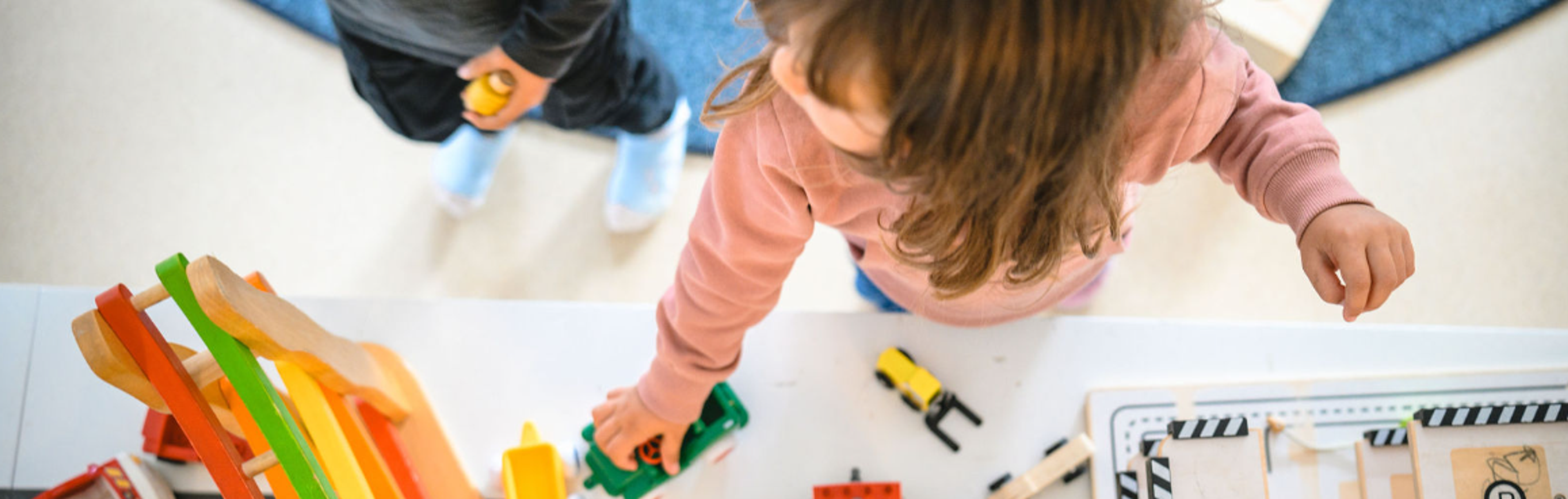 två barn lekar med bilar, bilden tagen uppifrån