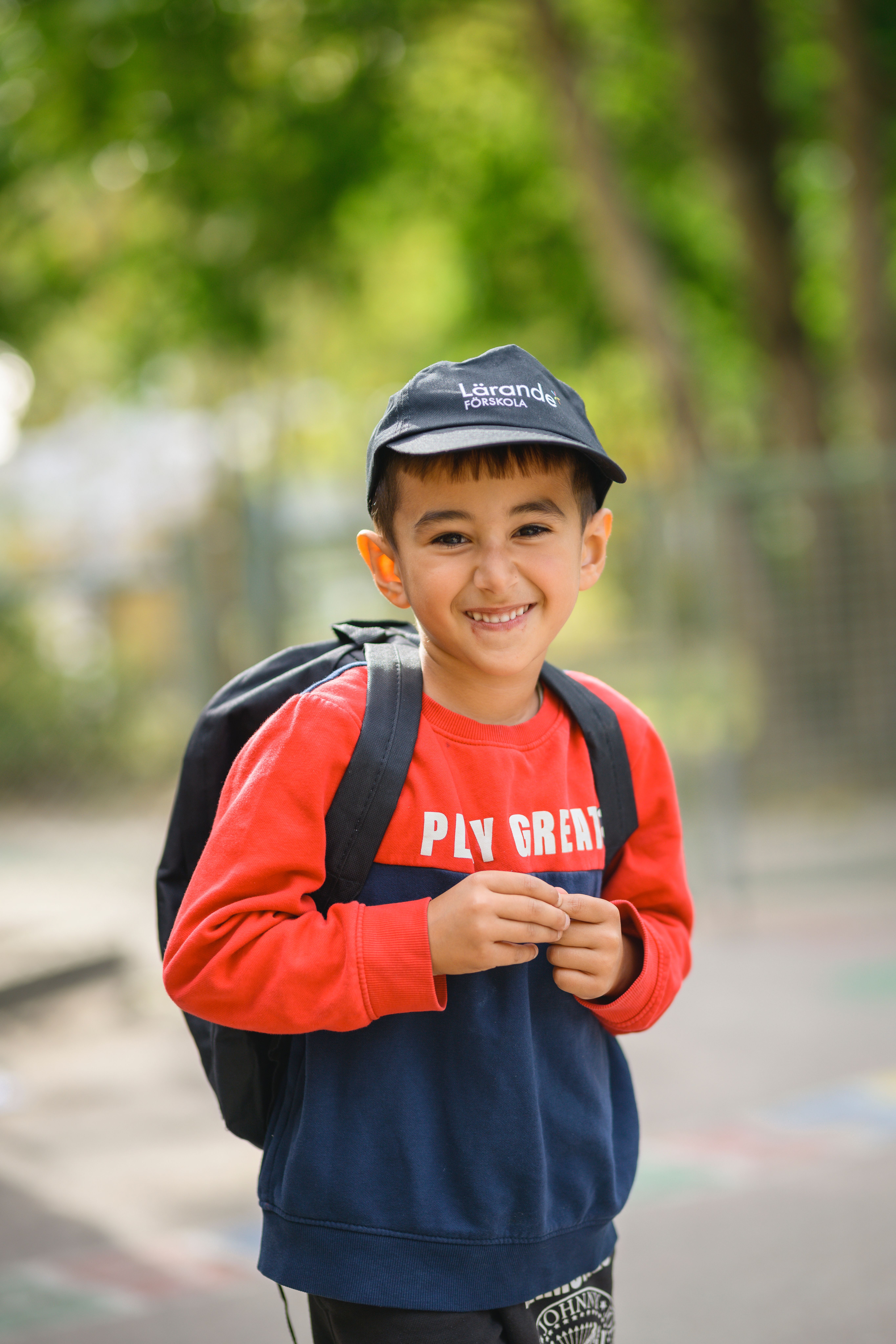 Barn med väska och lärande förskola keps