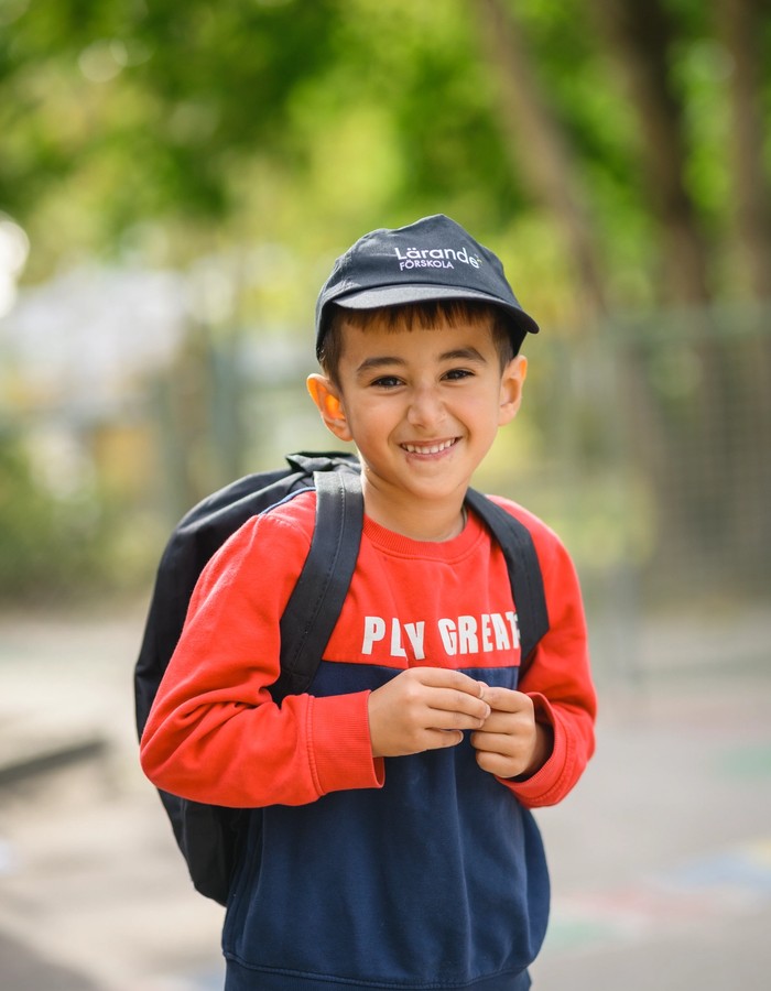 Barn med väska och lärande förskola keps