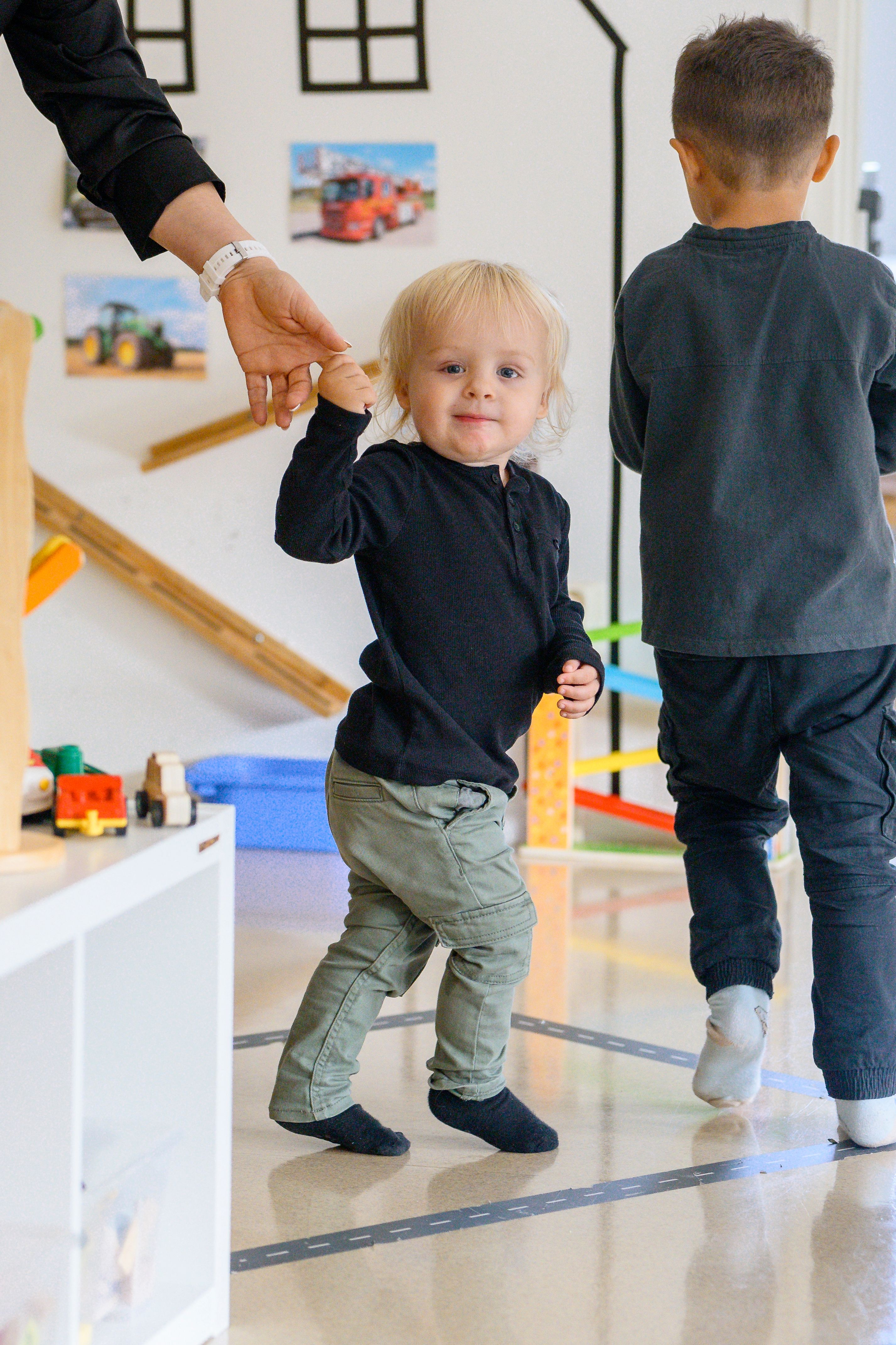 barn på språng med en pedagog i handen