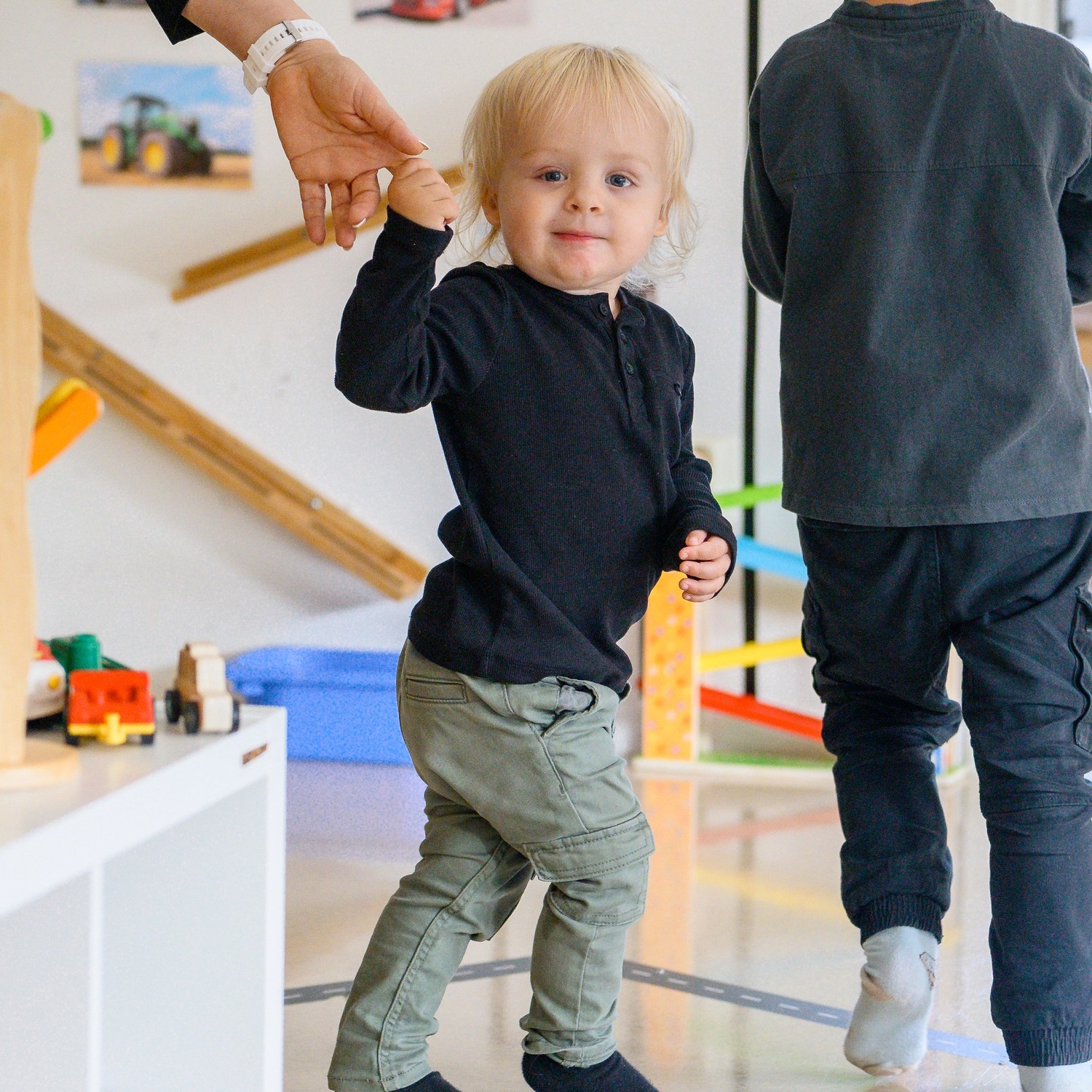 barn på språng med en pedagog i handen