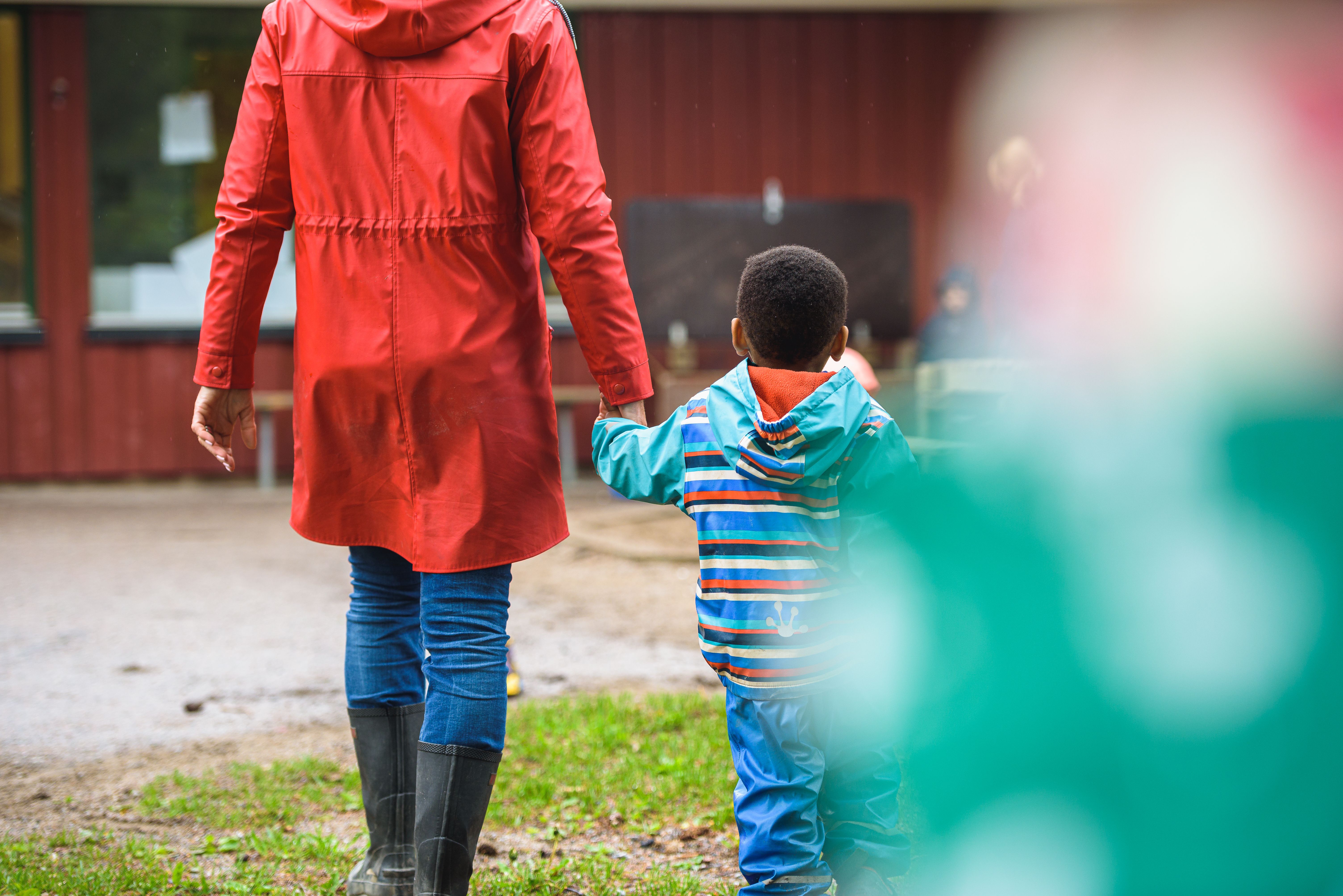 En flicka som häller grus i ett rör