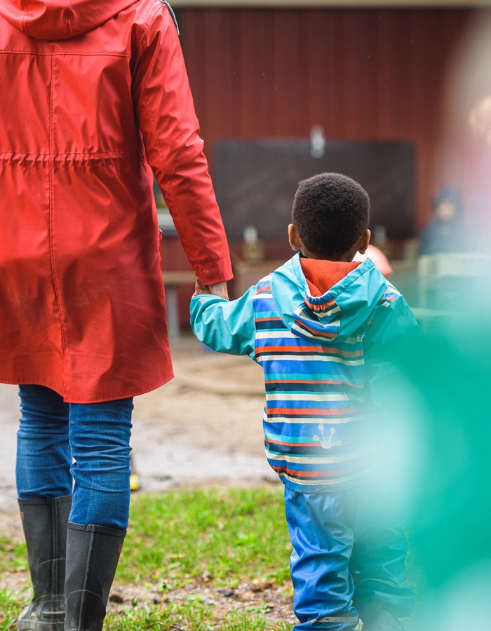 En flicka som häller grus i ett rör