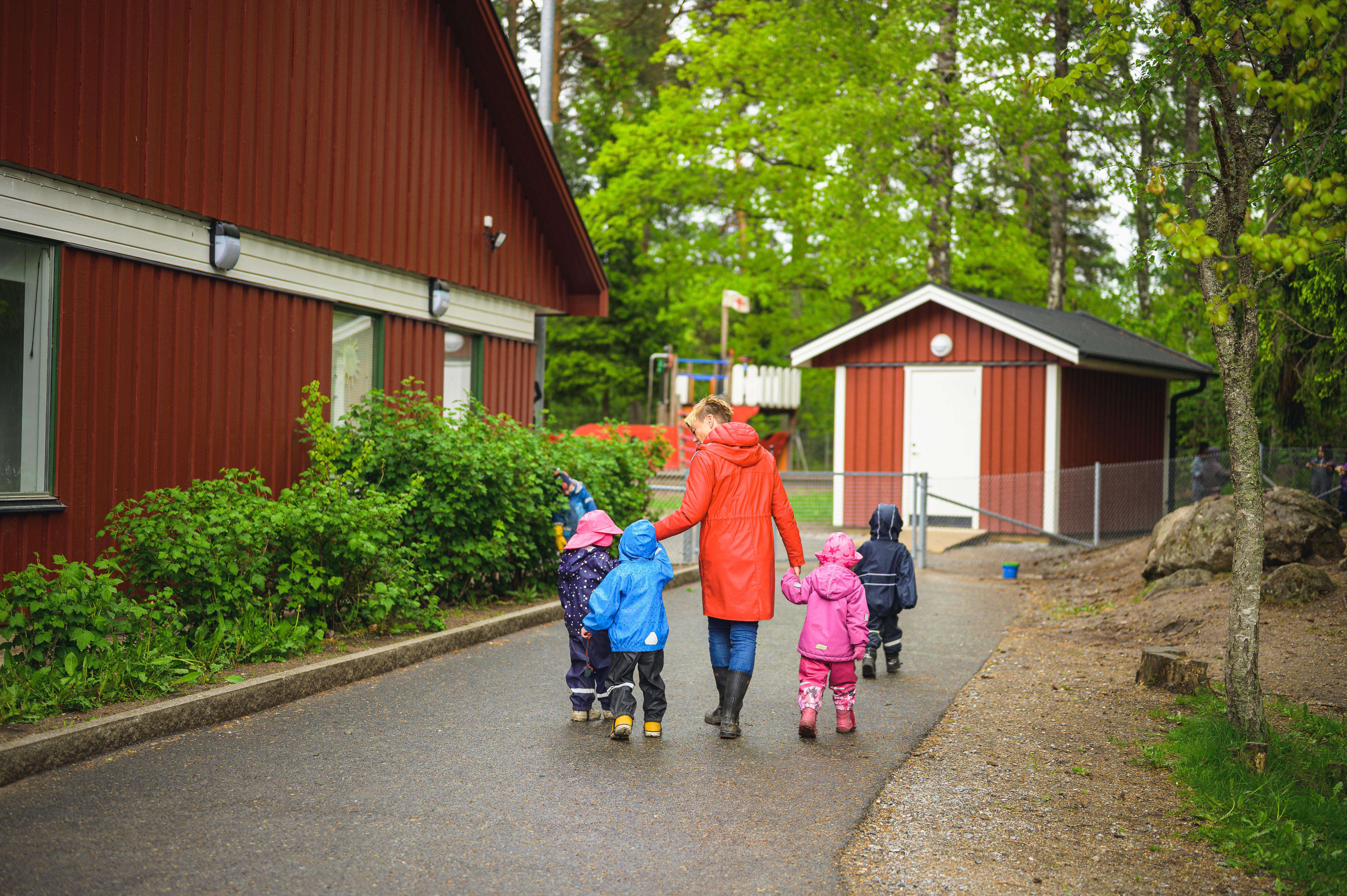Pedagog och fyra barn på gården