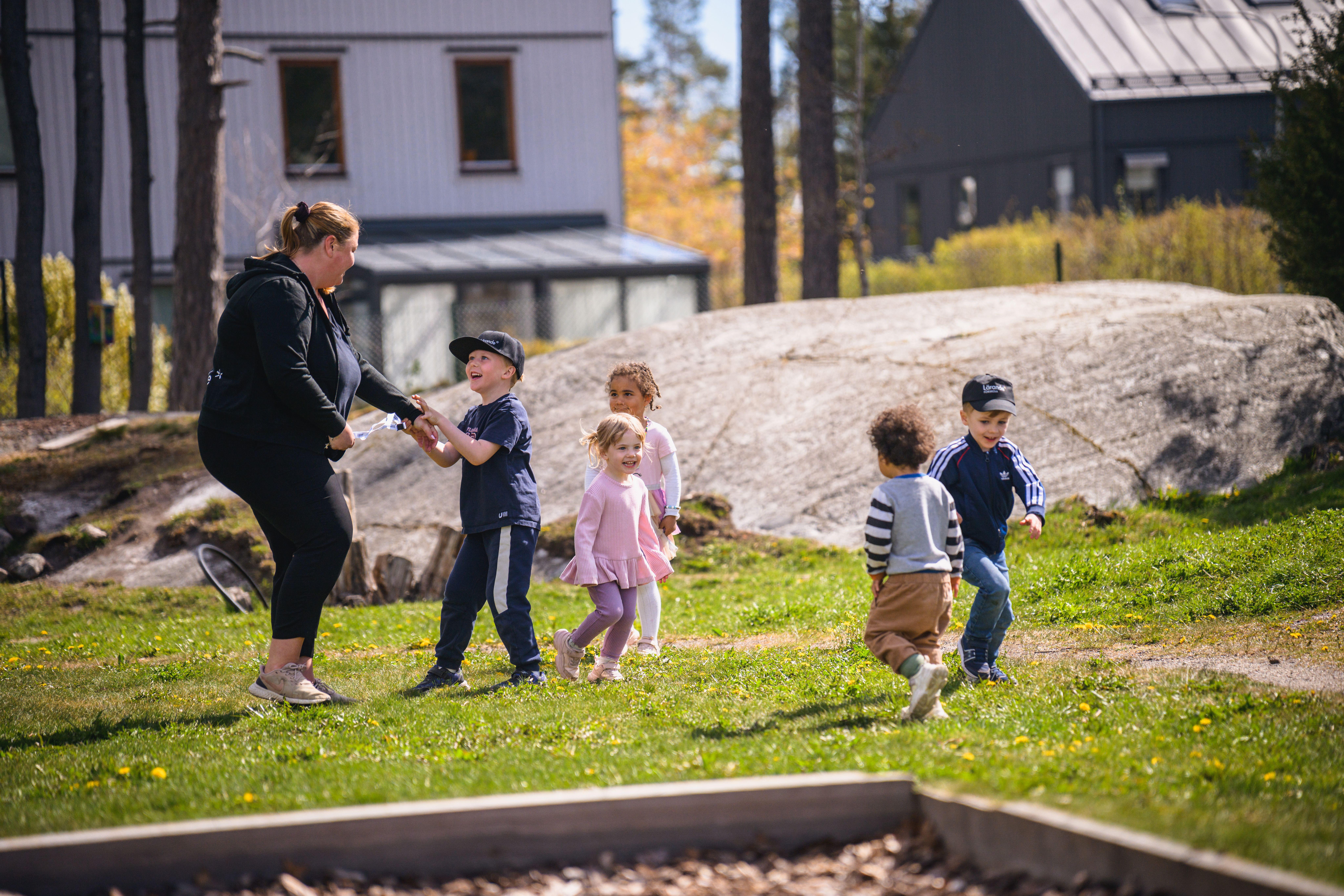  barn leker med pedagog utomhus