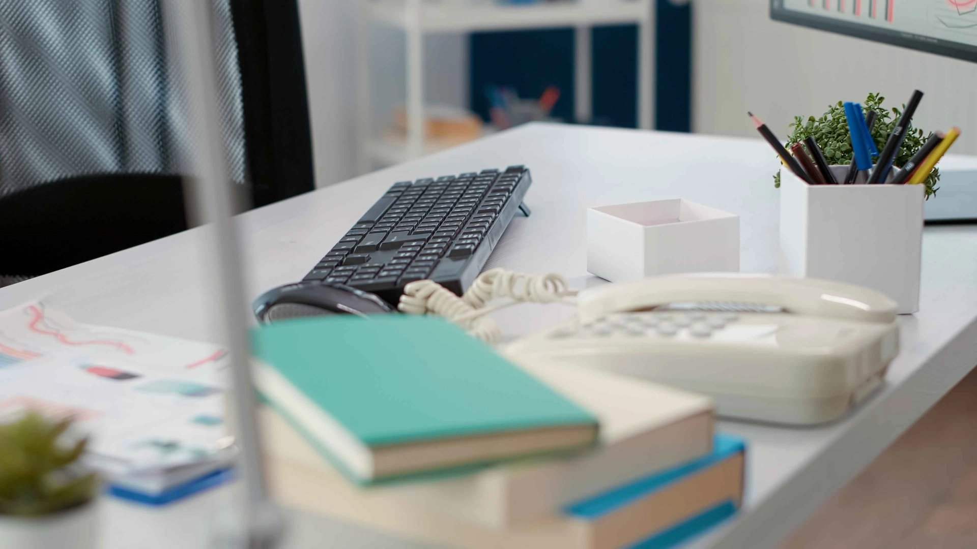 Office desk with keyboard, mouse and notepad.