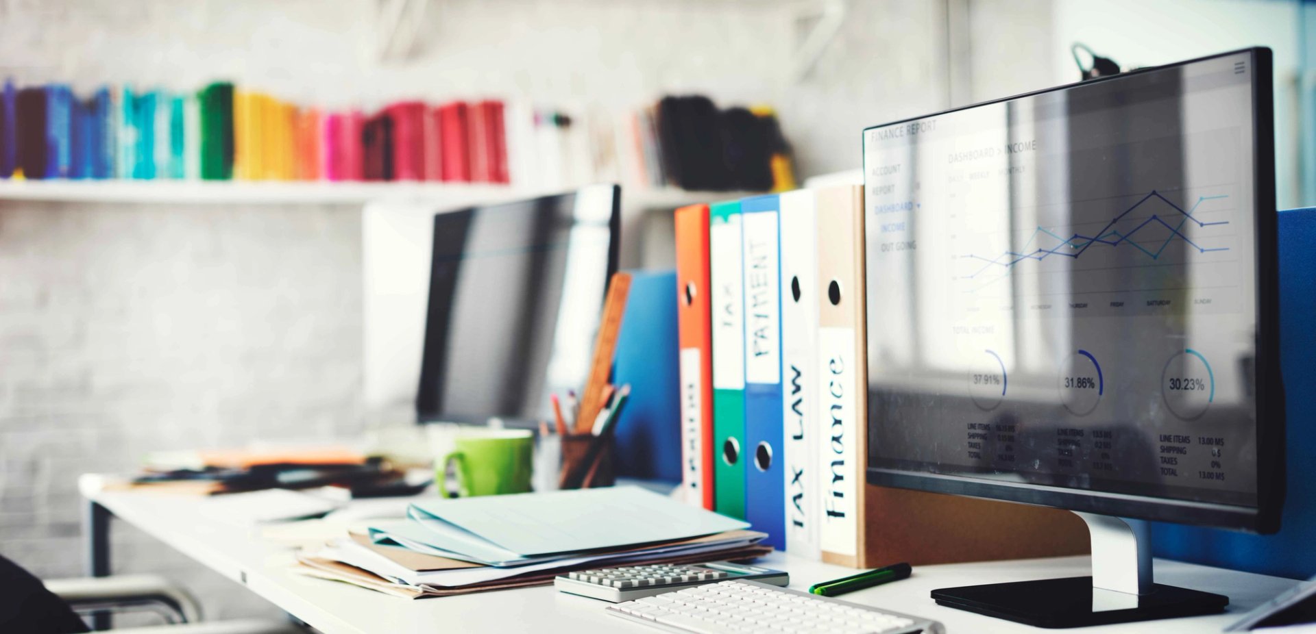 Colourful office setting with computers and general office supplies.