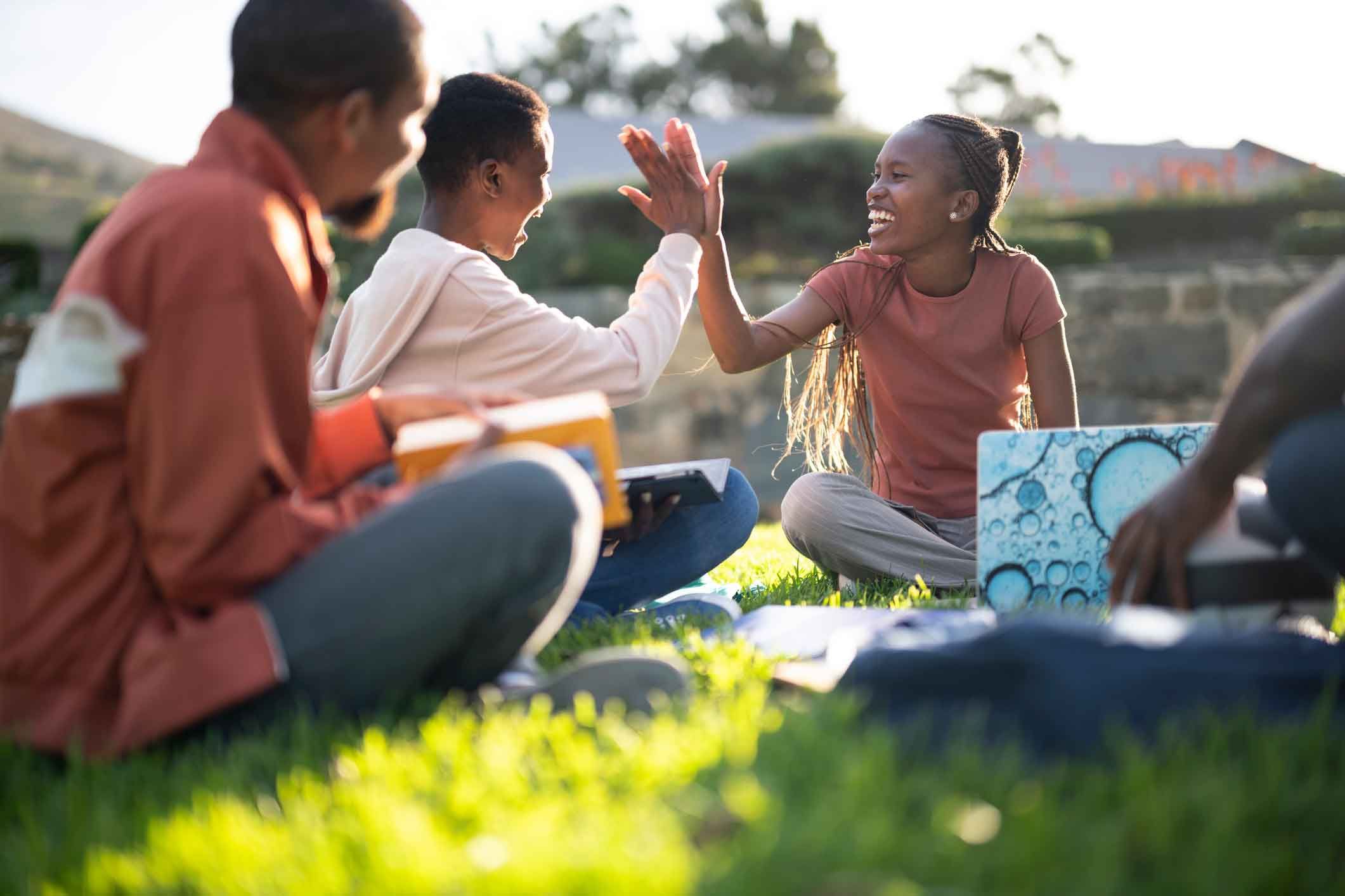 Students socialising outside on the grass