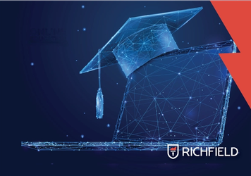 Graduation cap sitting on a laptop with Richfield logo in corner.