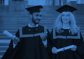 A man and woman in graduation attire holding qualifations