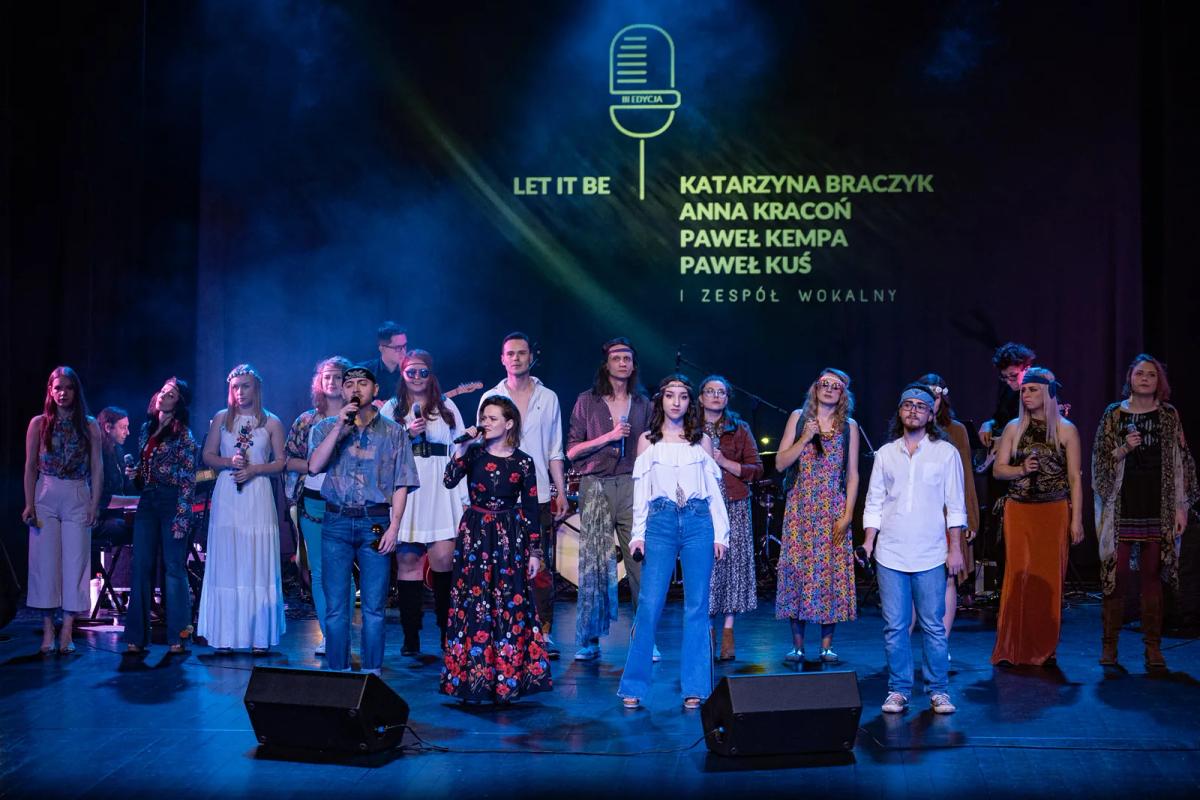 Uczestnicy koncertu finałowego stoją wspólnie na scenie przed publicznością.