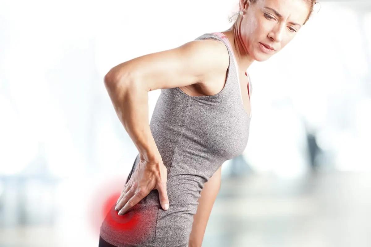 Person holding their lower back in discomfort
