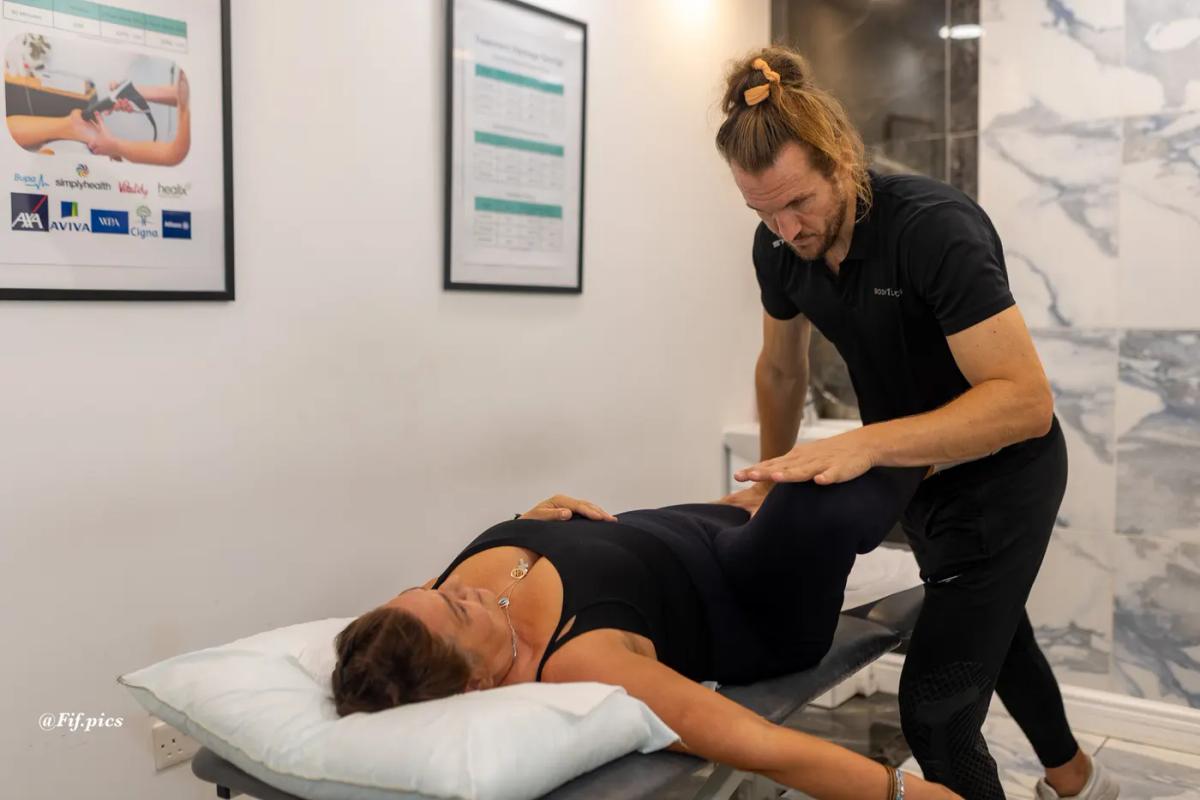 Physiotherapist assessing a patient's hip