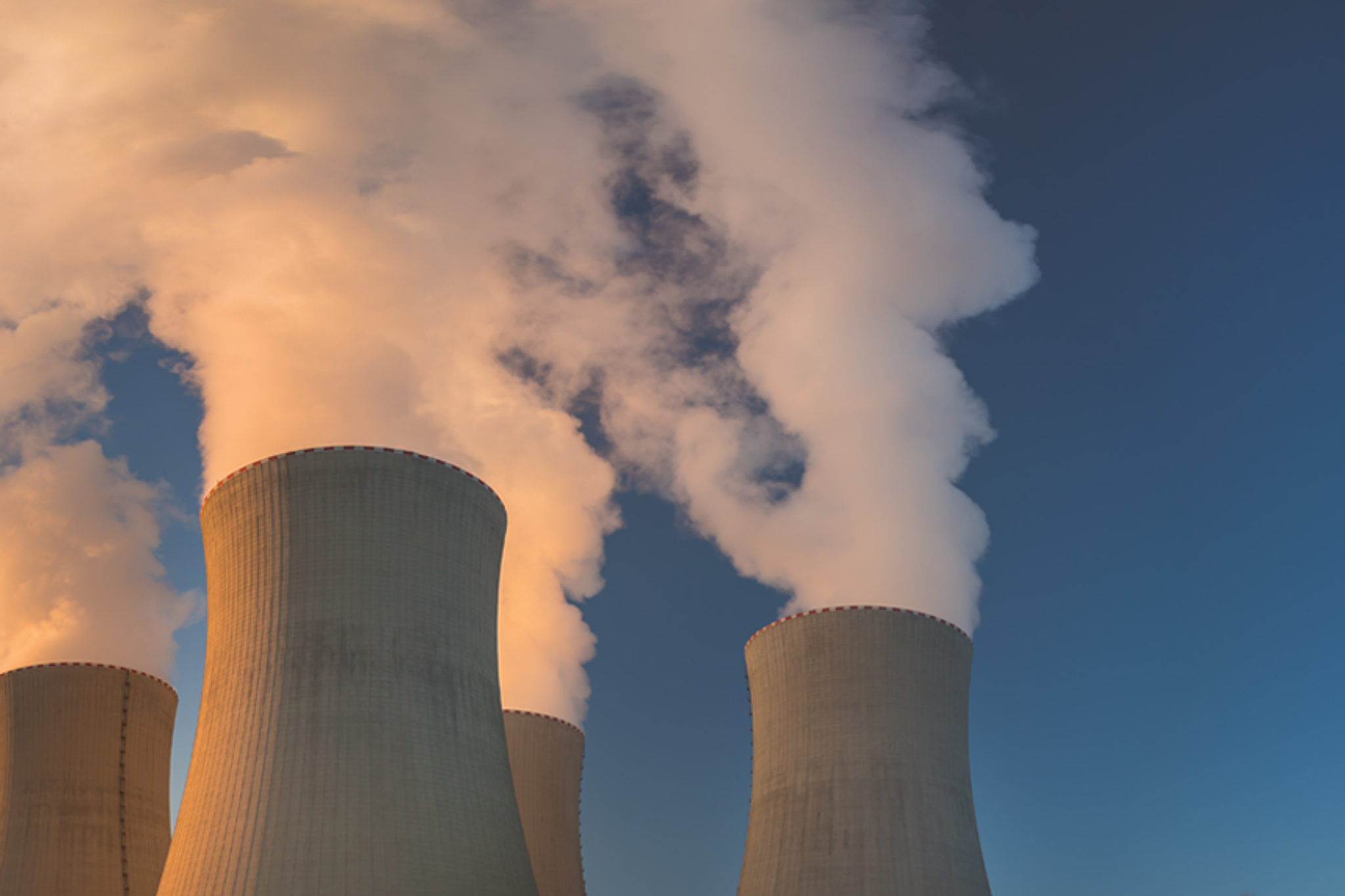 Tours de refroidissement d’une centrale électrique rejetant de grands panaches de vapeur.