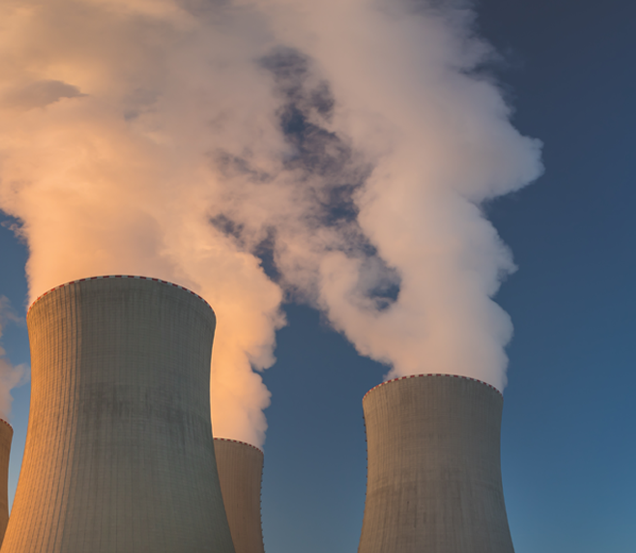 Tours de refroidissement d’une centrale électrique rejetant de grands panaches de vapeur.