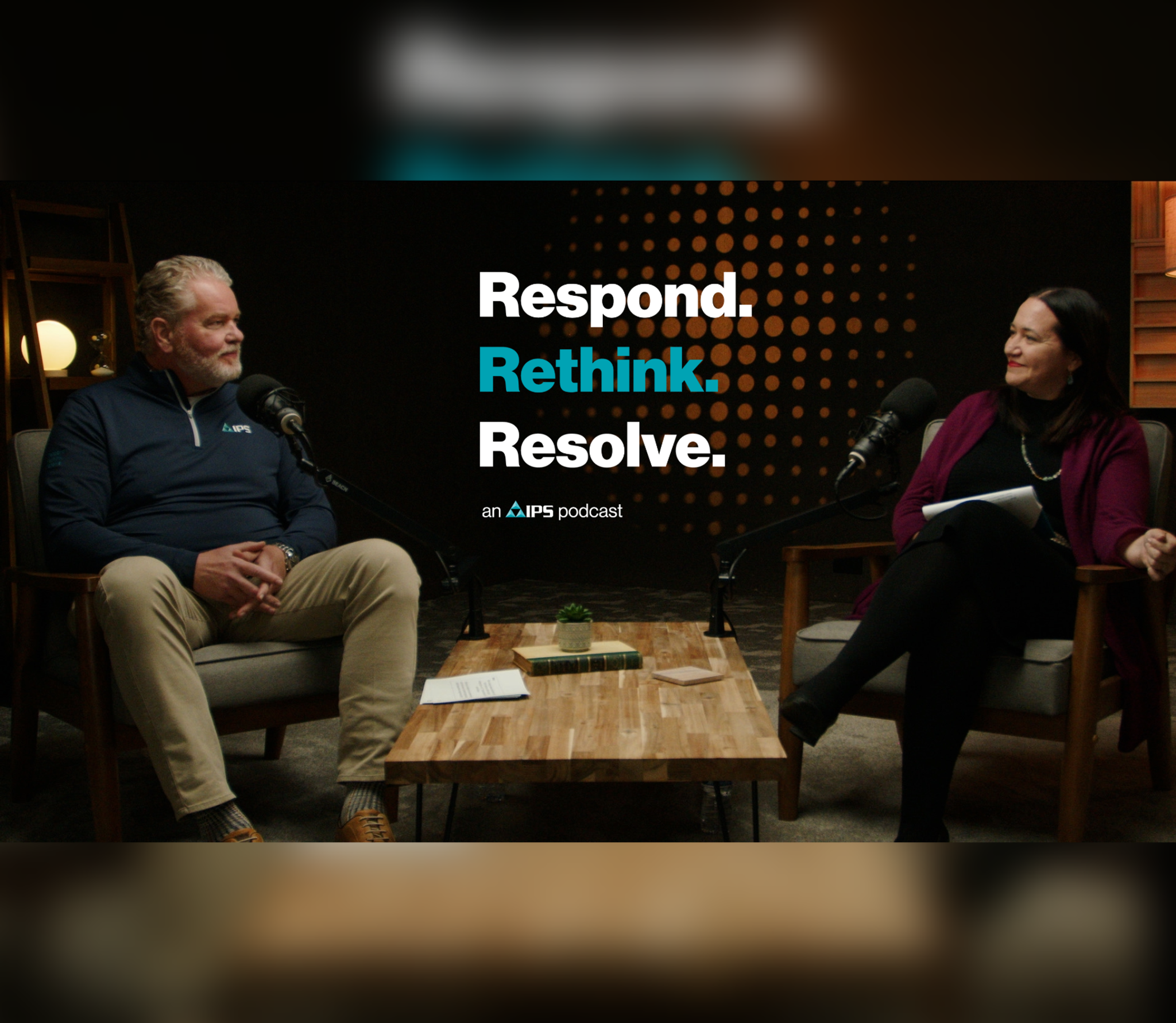 Two hosts speak into microphones on the IPS Respond. Rethink. Resolve. podcast set.