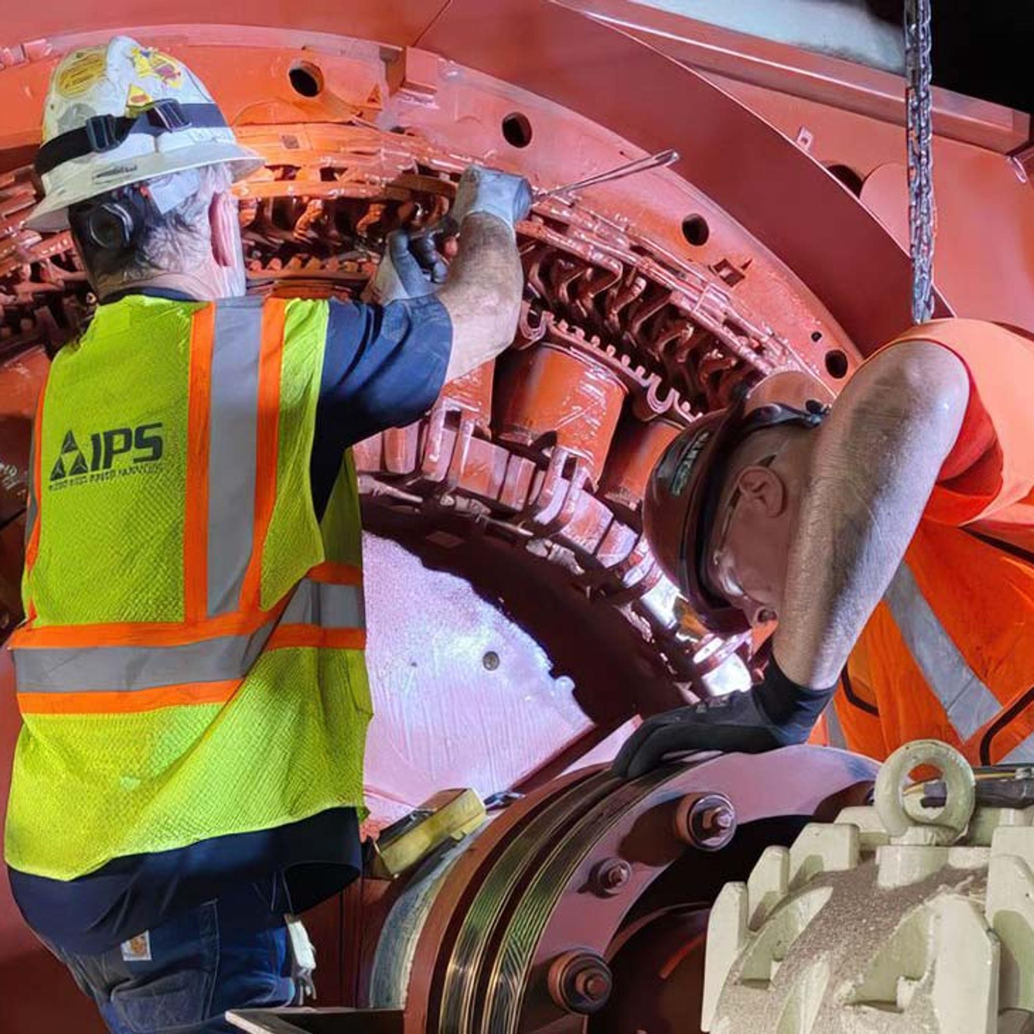 IPS technicians inspect and service the internal components of a large industrial generator.