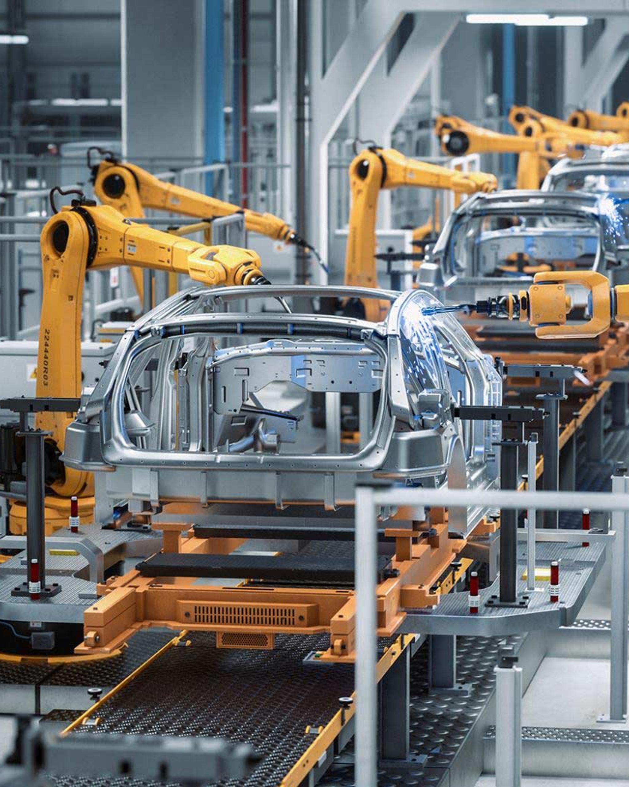 Brazos robóticos sueldan carrocerías de automóviles en una línea de ensamblaje industrial.