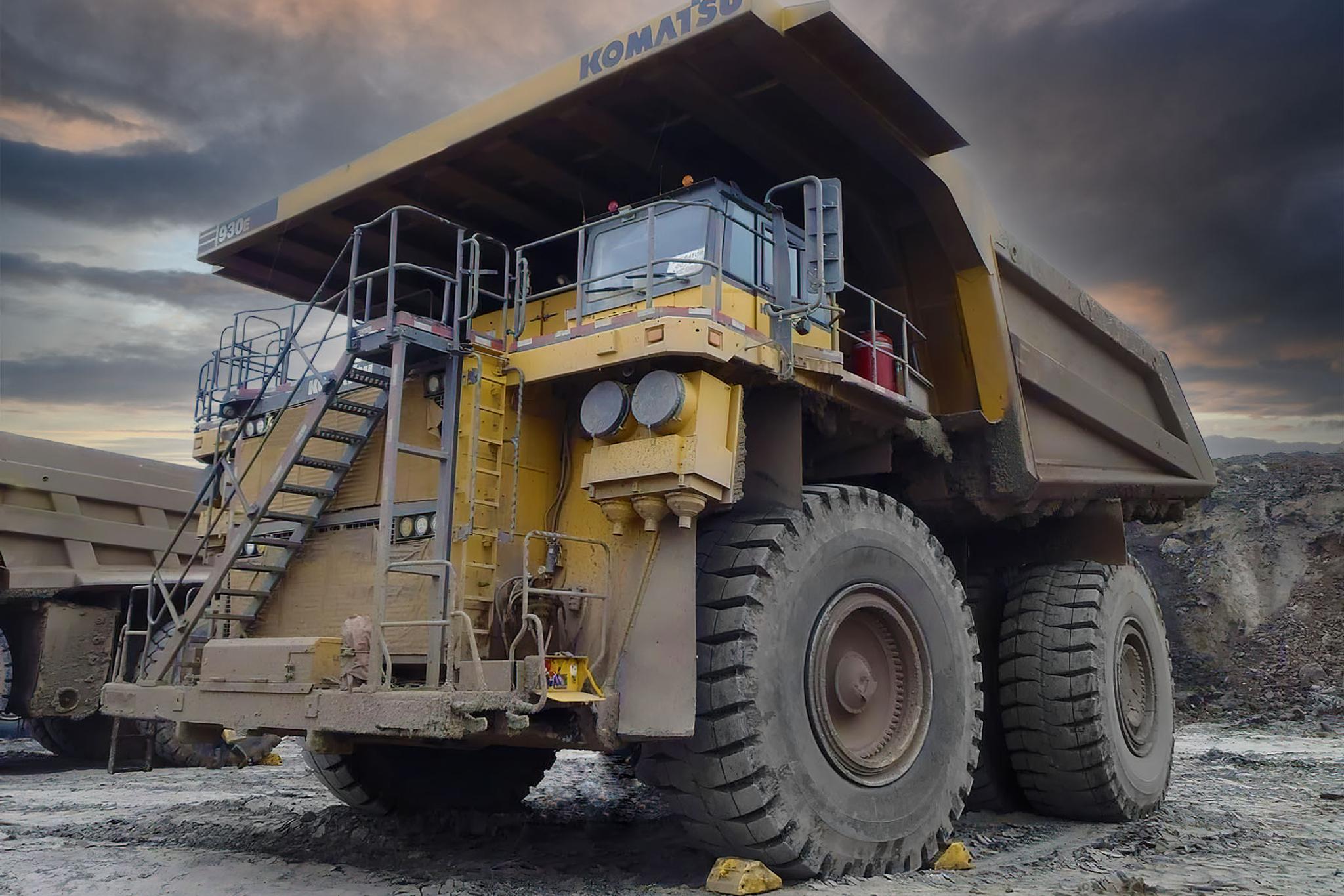 Camión minero Komatsu 930E estacionado en una cantera bajo un cielo nublado.