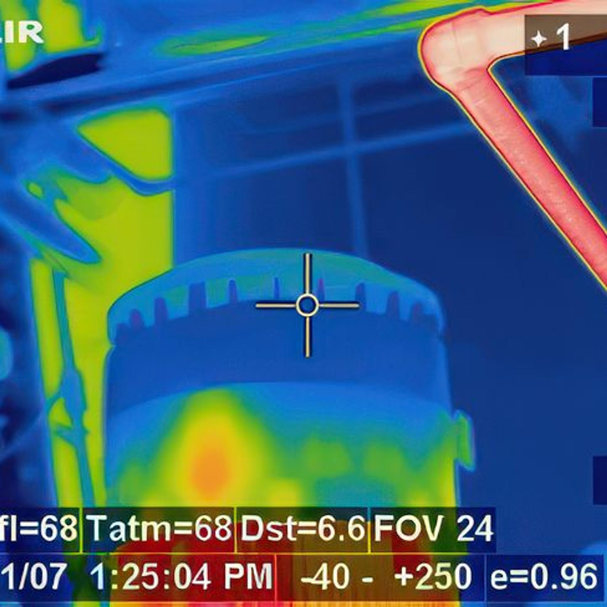 Thermal camera view shows heat patterns on an electric motor and nearby piping.