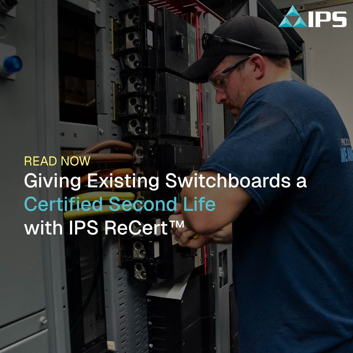 A man in safety glasses and a cap works on an open electrical switchboard, promoting IPS ReCert™.