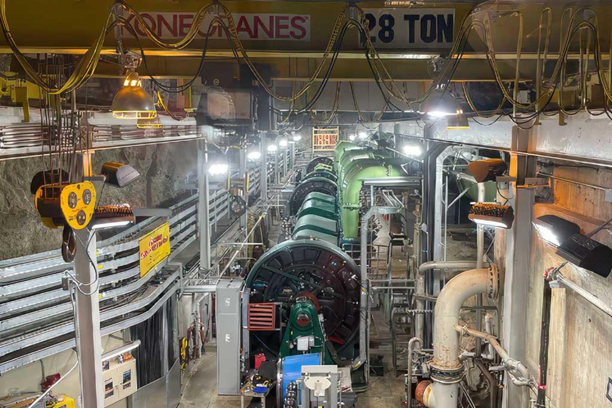 Large industrial generator and piping beneath a 28-ton overhead crane in a power plant.