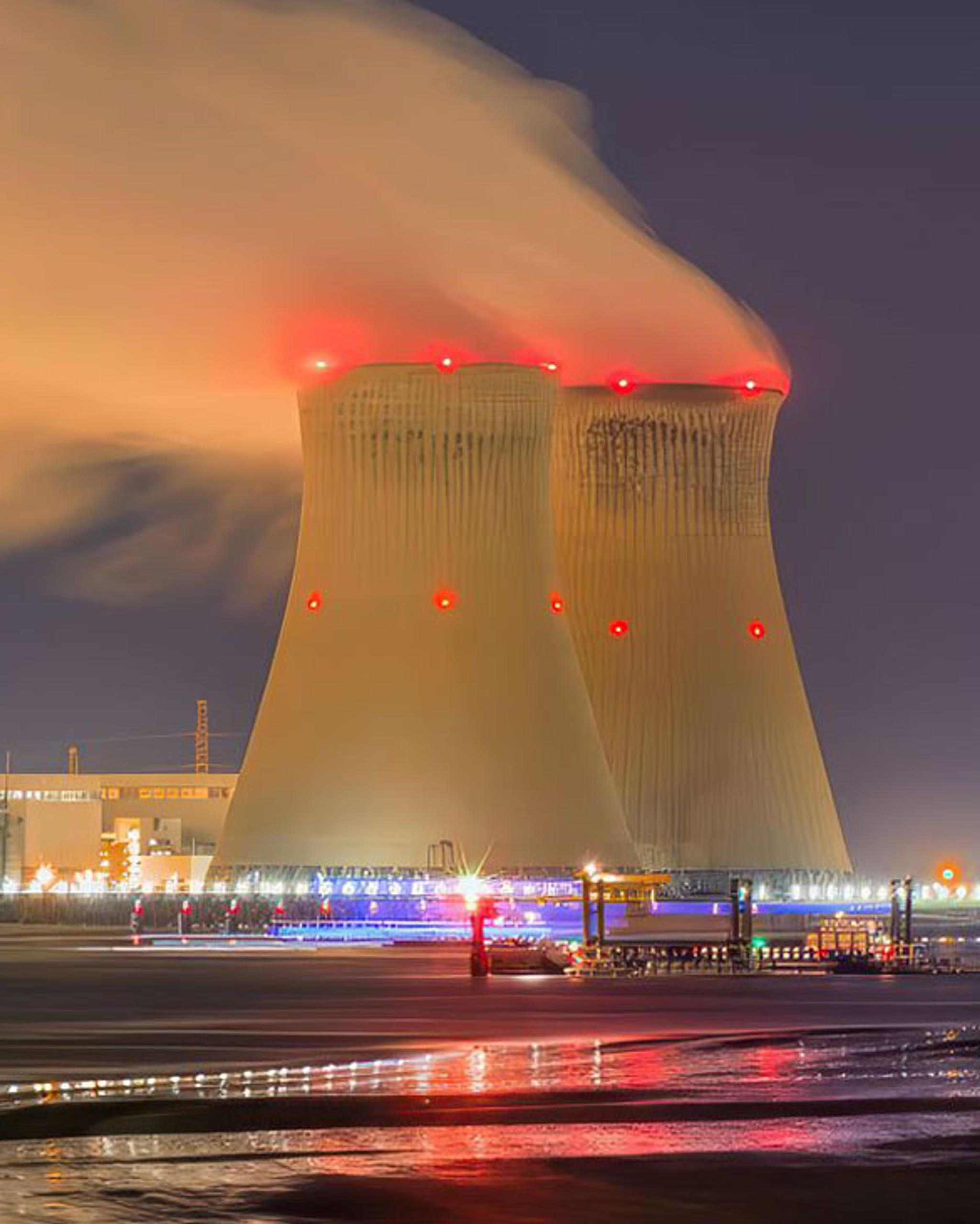 Torres de refrigeración de una central eléctrica expulsan vapor durante la noche.