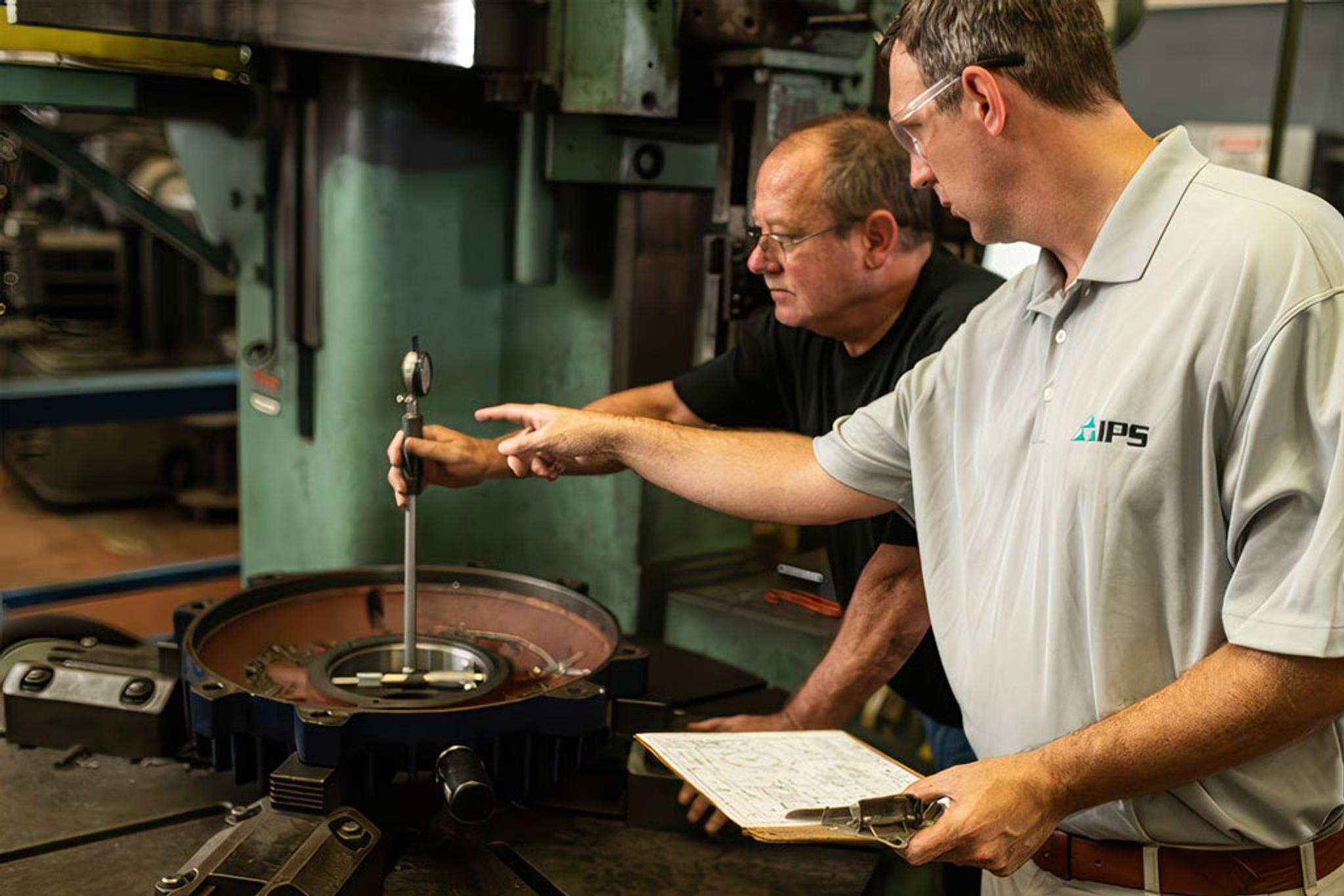 Técnicos de IPS miden con un comparador el alojamiento de un componente de motor industrial.