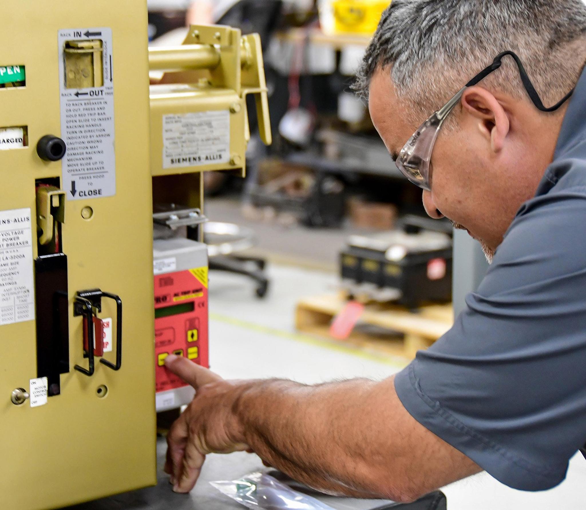 Un technicien règle le panneau de commande d’un appareillage de commutation Siemens Allis.