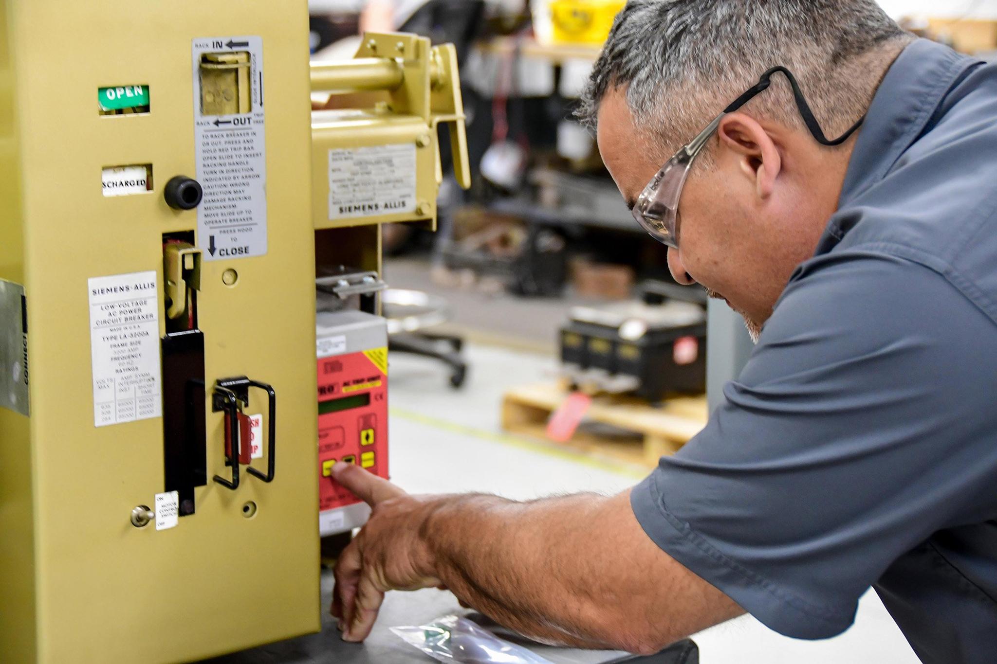 Un technicien règle le panneau de commande d’un appareillage de commutation Siemens Allis.