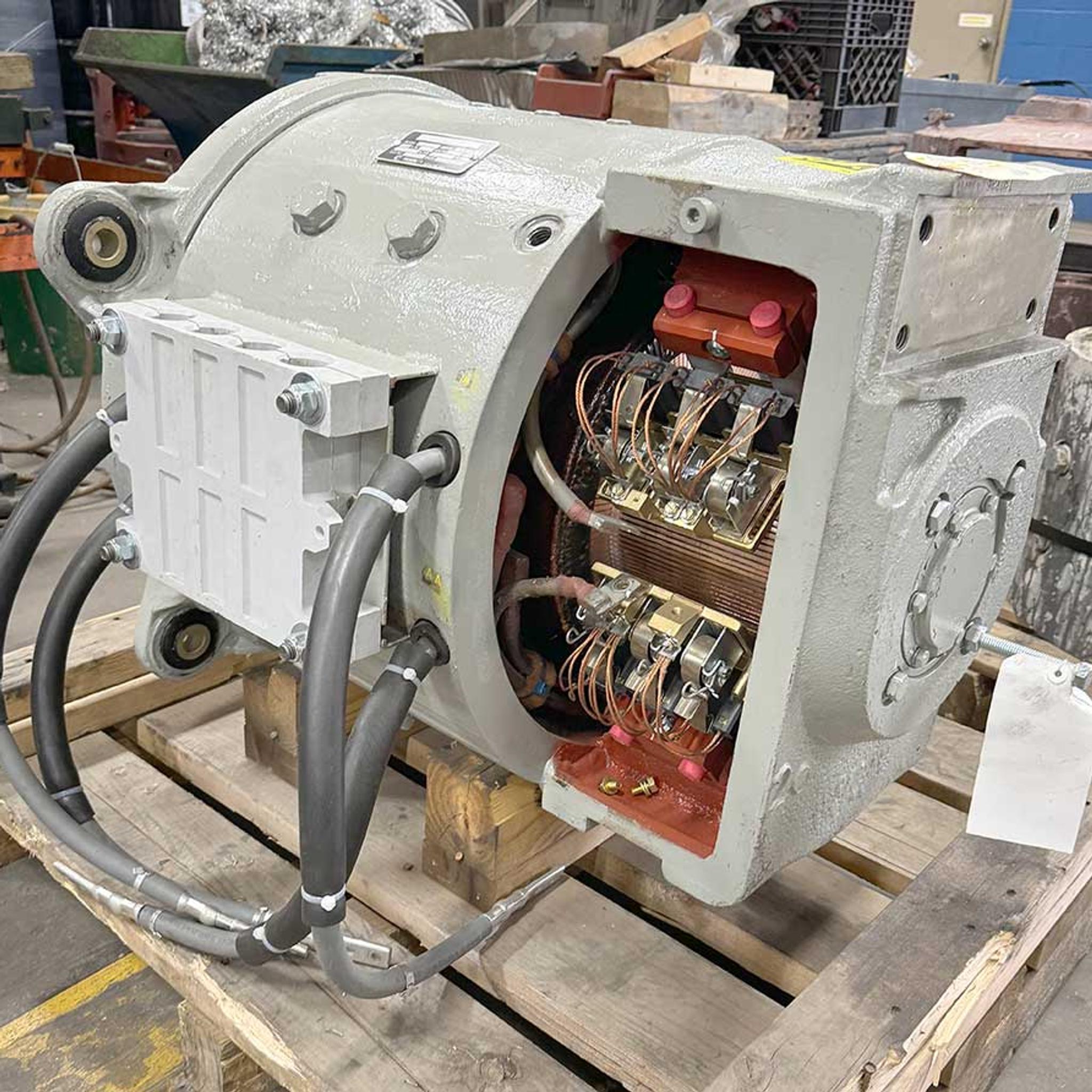 Industrial motor on a pallet with its electrical wiring and internal components exposed for service.