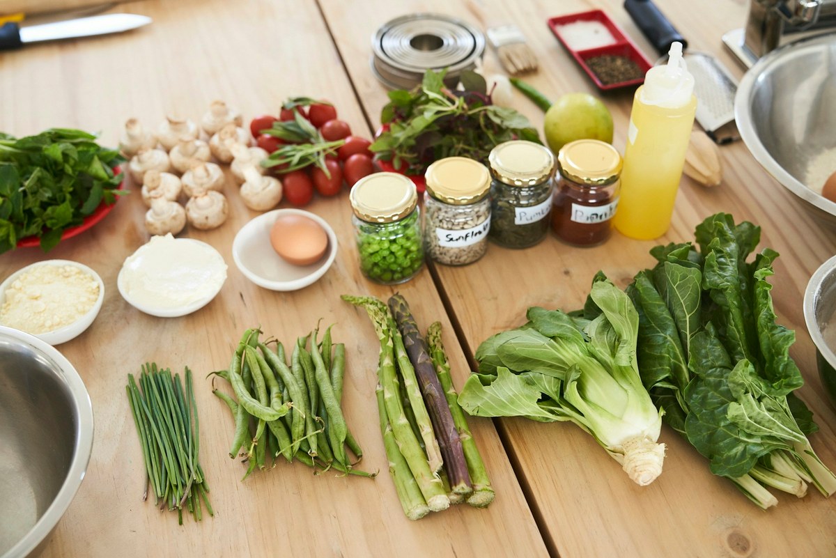 Légumes frais, graines et ingrédients disposés sur une table en bois
