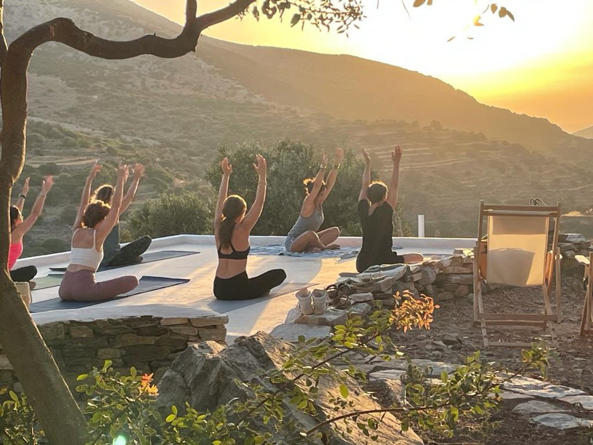 Séance collective de yoga en extérieur, face aux montagnes